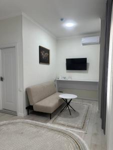 a living room with a couch and a table at BOG'DON GRAND Hotel in Tashkent