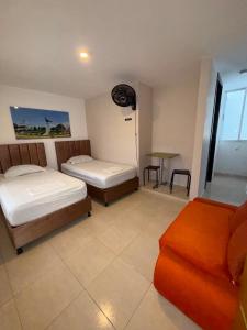 a room with two beds and a couch in it at Villalba Boutique Hotel in Valledupar