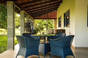 a patio with chairs and a table on a porch at Hotel Pousada Flor de Alecrim - Goiana in Goiana