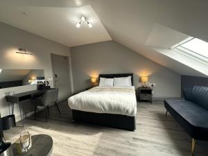 a bedroom with a bed and a desk and a couch at Amorist Hotel in Dunfermline