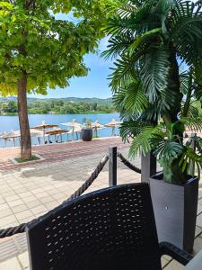 a patio with two chairs and a tree and water at KM Lux & SPA in Veliko Gradište