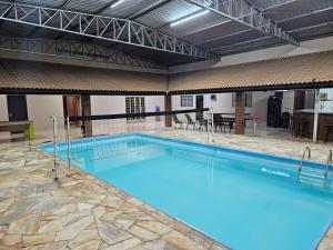 a large swimming pool with blue water in a building at Chácara HZ in Sao Jose do Rio Preto