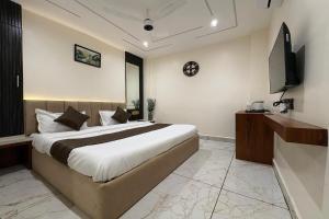 a bedroom with a large bed and a television at Hotel Anantshree Inn Shree Mahakaleshwar Temple Ujjain in Ujjain +52 photos