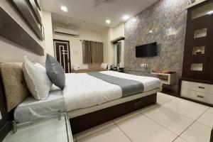 a bedroom with a large bed and a television in it at Hotel Anantshree Inn Shree Mahakaleshwar Temple Ujjain in Ujjain