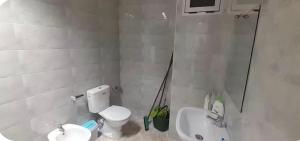 a white bathroom with a toilet and a sink at Apartamento dina 13 in Fnidek +3 photos