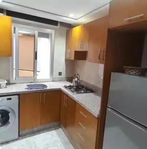 a kitchen with a stove and a white refrigerator at Apartamento dina 13 in Fnidek