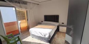 a small bedroom with a bed and a chair at Apartamento dina 13 in Fnidek