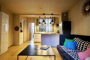 a living room with a couch and a table at T2 intra muros clim et cour ombragée in Avignon