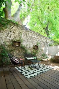 two chairs and a table on a wooden deck at T2 intra muros clim et cour ombragée in Avignon