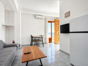 a living room with a couch and a table at The Icarian resort Dourediko 2 by BRP-PROPERTIES in Evdilos