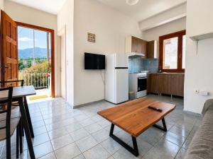 a living room with a table and a kitchen at The Icarian resort Dourediko 2 by BRP-PROPERTIES in Evdilos