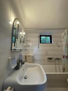 a white bathroom with a sink and a bath tub at Olive & Sea Villa Koroni in Koroni +28 photos