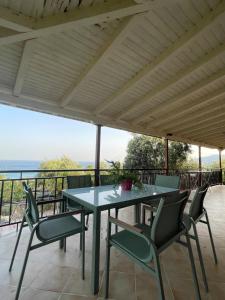 a table and chairs on a patio with a view of the ocean at Olive & Sea Villa Koroni in Koroni