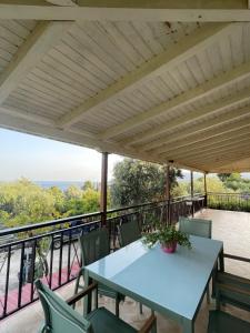 a patio with a table and chairs on a balcony at Olive & Sea Villa Koroni in Koroni