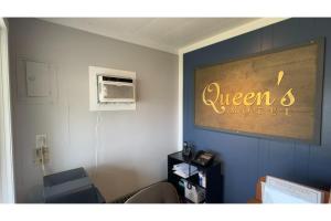 a room with a sign that says queen and motel at Queen's Motel Blenheim Near Lake Erie ON in Blenheim