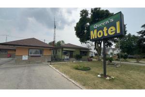 a sign for a motel in front of a house at Queen's Motel Blenheim Near Lake Erie ON in Blenheim