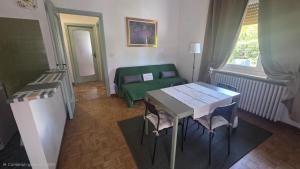 a room with a table and chairs and a bed at Green House Residence in Pinerolo