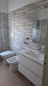 a bathroom with a toilet and a sink and a mirror at Green House Residence in Pinerolo +5 photos