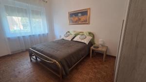 a bedroom with a bed with a window and a table at Green House Residence in Pinerolo