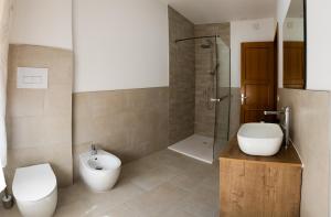 ein Badezimmer mit Toilette, Waschbecken und Dusche in der Unterkunft Alifrasi in La Caletta