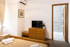 ein Schlafzimmer mit einem Fernseher und einer Kommode mit einem Fernseher darauf in der Unterkunft Alifrasi in La Caletta