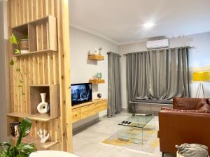 a living room with a couch and a television at Sarona LoLa E206 in Gaborone