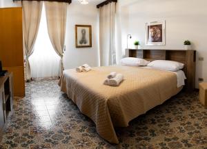 ein Schlafzimmer mit einem Bett, auf dem Handtücher liegen in der Unterkunft Alifrasi in La Caletta