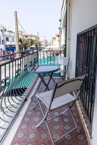 zwei Stühle und ein Tisch auf einem Balkon in der Unterkunft Alifrasi in La Caletta