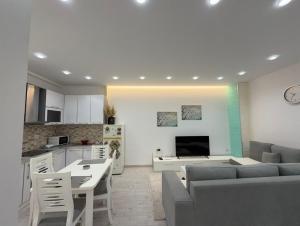a kitchen and a living room with a couch and a table at Paco Apartment Center Shkoder in Shkodër +9 photos