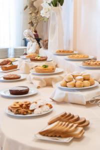 a long table with plates of food on it at Hotel Globus Pool & Beach in Milano Marittima