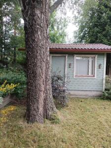a small house with a tree in front of it at Heritage House at Villa Sofia in Lahti