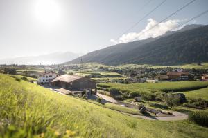 a village on a hill with mountains in the background at Hell Hof in Innsbruck