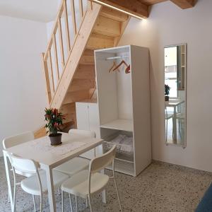 a dining room with a table and chairs and a staircase at Casa Ninetta in Pimonte