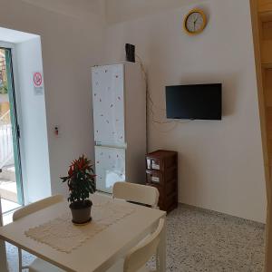 a dining room with a table and a tv on a wall at Casa Ninetta in Pimonte