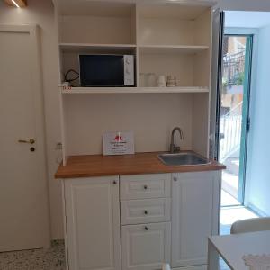 a kitchen with a counter with a sink and a microwave at Casa Ninetta in Pimonte +1 photo