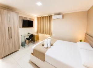 a hotel room with a bed and a desk at Hotel Itaparica in Caruaru