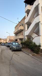 a parking lot with cars parked next to a building at La terrazza della Scala in Porto Empedocle