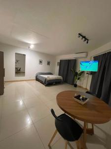 a living room with a table and a bed at Apart Escobar in Belén de Escobar +3 photos