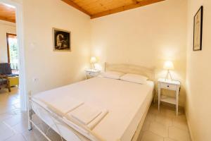 ein Schlafzimmer mit einem Bett, zwei Nachttischen und zwei Lampen in der Unterkunft Villa Vanda in Ligia