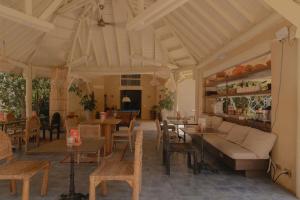 a living room with tables and chairs and a couch at Arde La Selva in Santa Fe de Antioquia