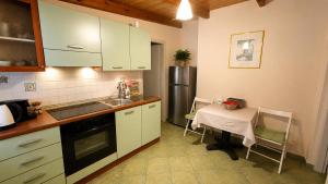 eine Küche mit weißen Schränken, einem Tisch und einem Kühlschrank in der Unterkunft Villa Vanda in Ligia