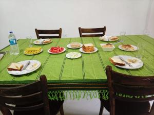 a green table with plates of food on it at Sigiri Rew Haven in Sigiriya +40 photos