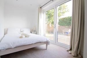a bedroom with a bed and a large window at Coopers by the Coast in Selsey