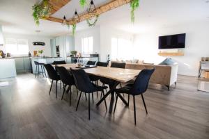 a dining room and living room with a wooden table and chairs at Coopers by the Coast in Selsey