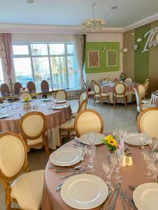 a dining room with tables and chairs with plates and glasses at Hotel Parc in Mamaia