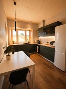 a kitchen with a table and a white refrigerator at Ulila guesthouse in Ulila
