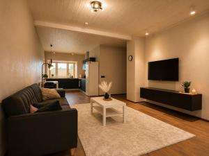 a living room with a couch and a tv at Ulila guesthouse in Ulila