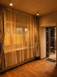 a living room with curtains and a window at Ulila guesthouse in Ulila