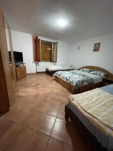 a room with three beds and a flat screen tv at Casa de vacanta Marian in Sâmbăta de Sus