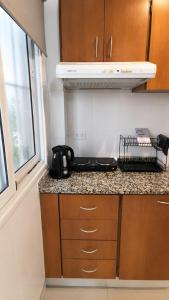 a kitchen counter with a black tea kettle on it at Apart Escobar in Belén de Escobar